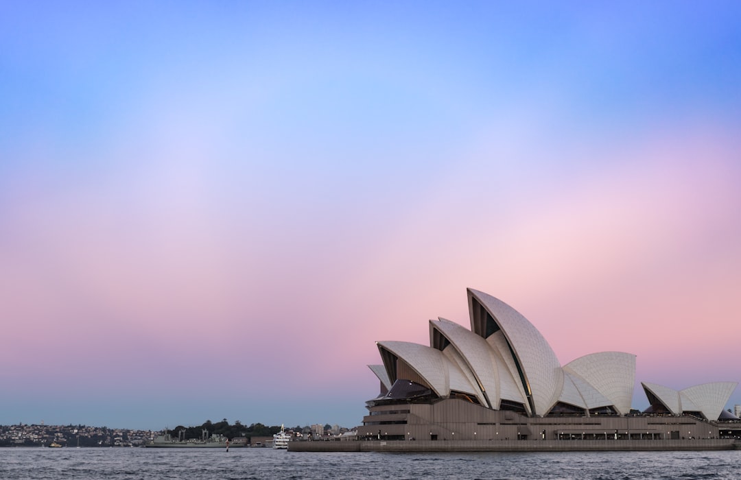 Sydney, Toronto, and London skylines with passport representing global work visa opportunities